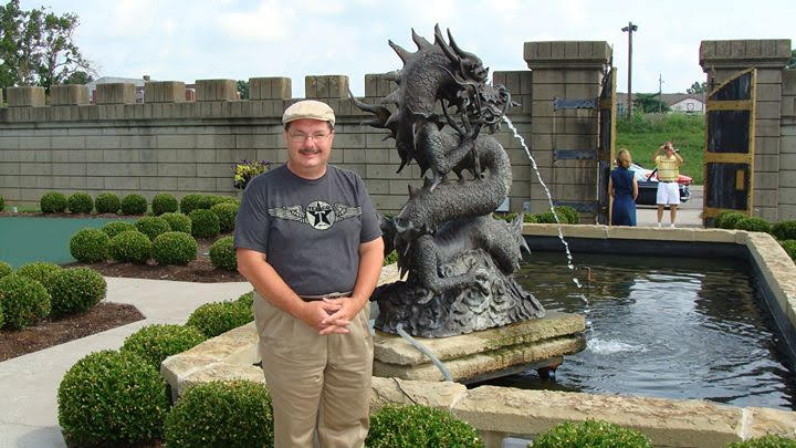 A man standing in front of a fountain.