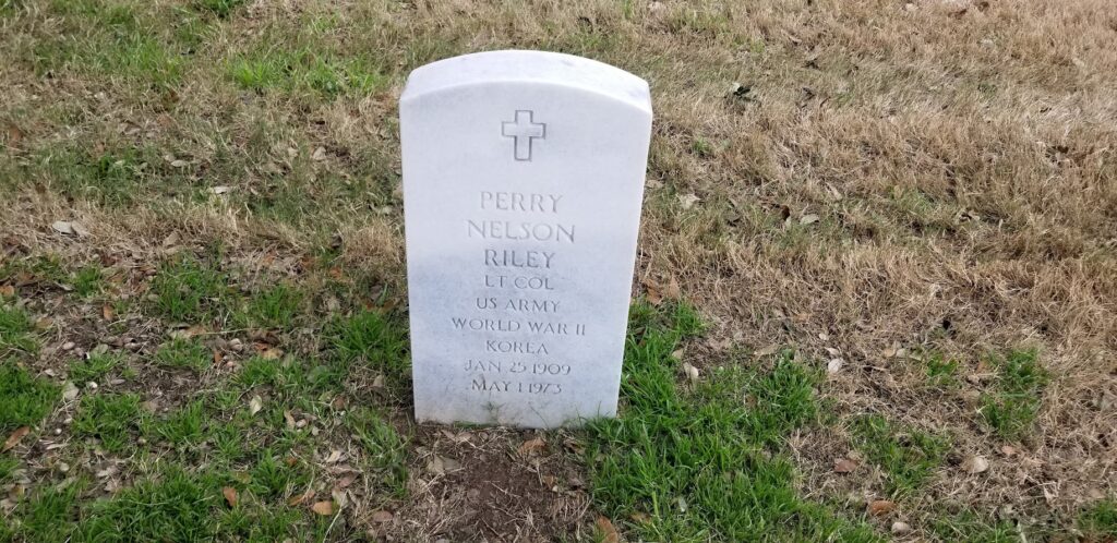 A white grave marker with a cross on it.