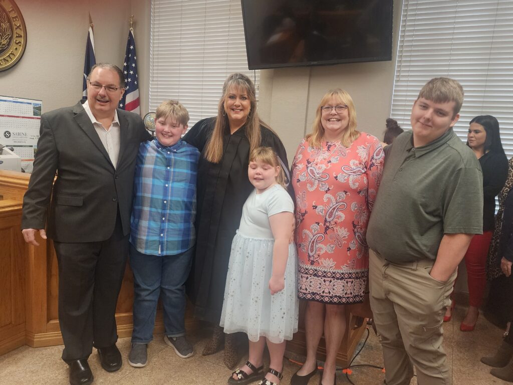 A family posing for a picture in front of the american flag.