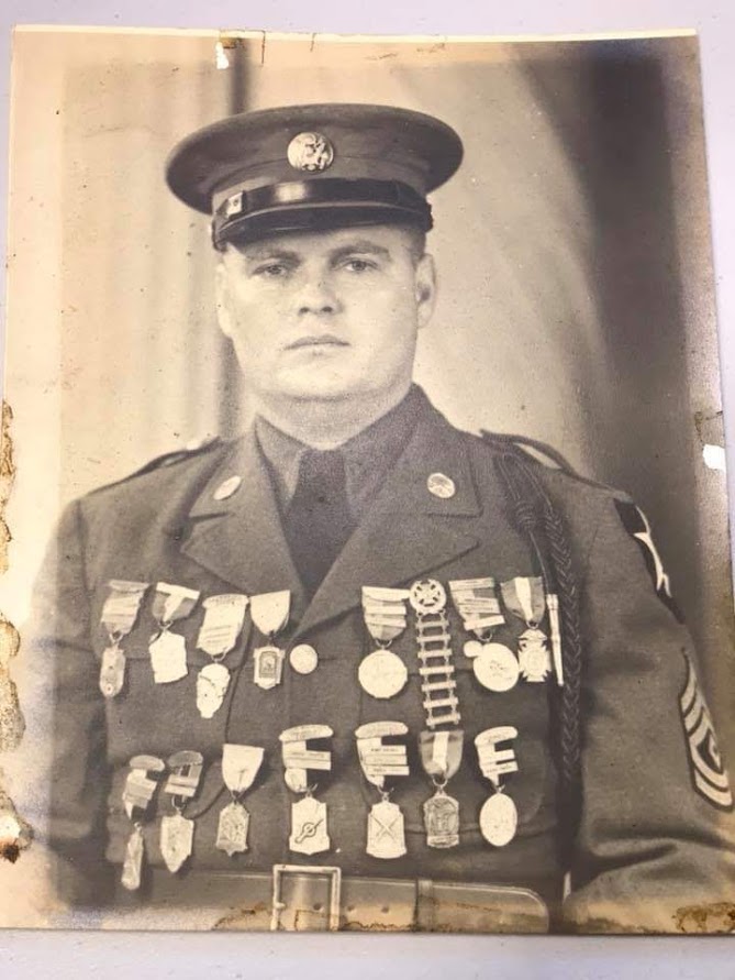 A man in uniform with many medals on his chest.