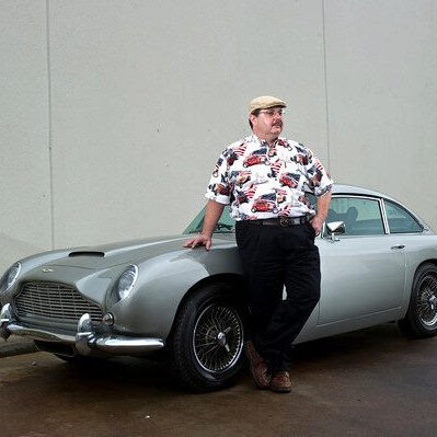 A man standing next to an old car